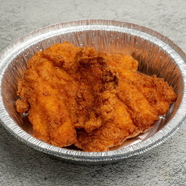 Golden-brown fried chicken pieces in a round, silver foil takeout container from Angie's Soul House.