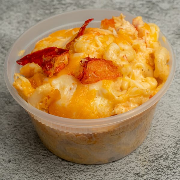 Angie's Soul House mac and cheese with lobster in a clear plastic container.