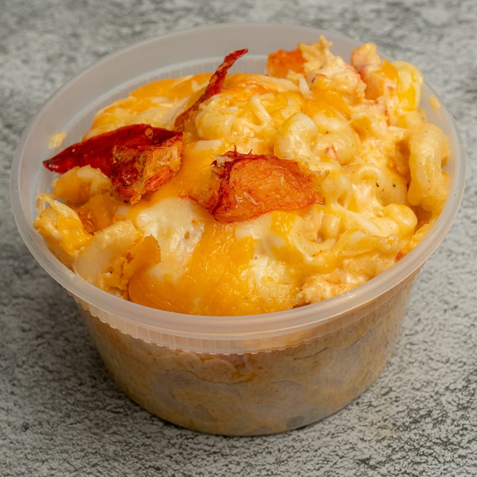 Angie's Soul House mac and cheese with lobster in a clear plastic container.
