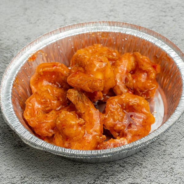 Angie's Soul House's saucy orange shrimp in a silver foil takeout container.