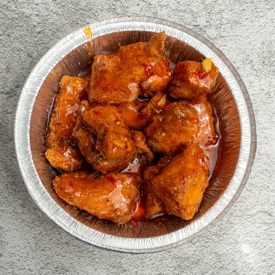 Angie's Soul House's sweet and spicy chicken wings in a foil container.