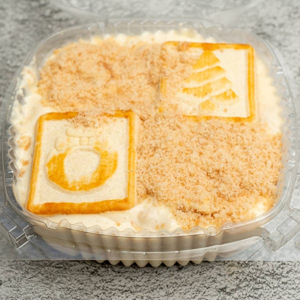 Angie's Soul House banana pudding with vanilla wafers and cookie crumbles in a clear container.